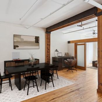 A dining room with a black table and chairs.
